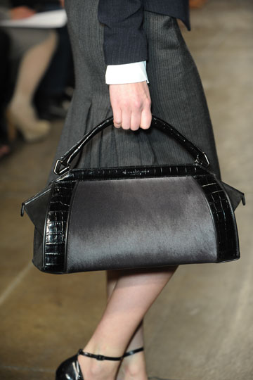 La clasica cartera negra infaltable en el vestuario de toda mujer en este caso Donna Karan vistio a sus modelos con este diseño